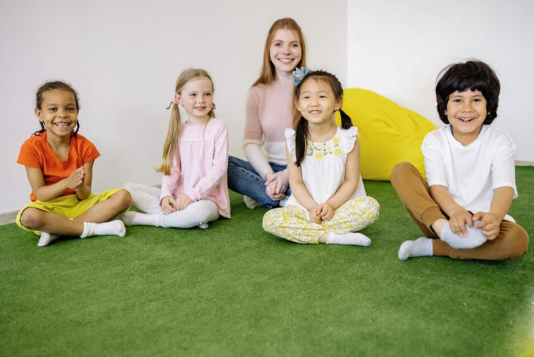 Therapist and group of smiling children sitting together