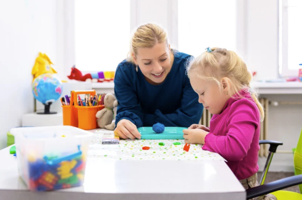 Therapist and child working together at craft table