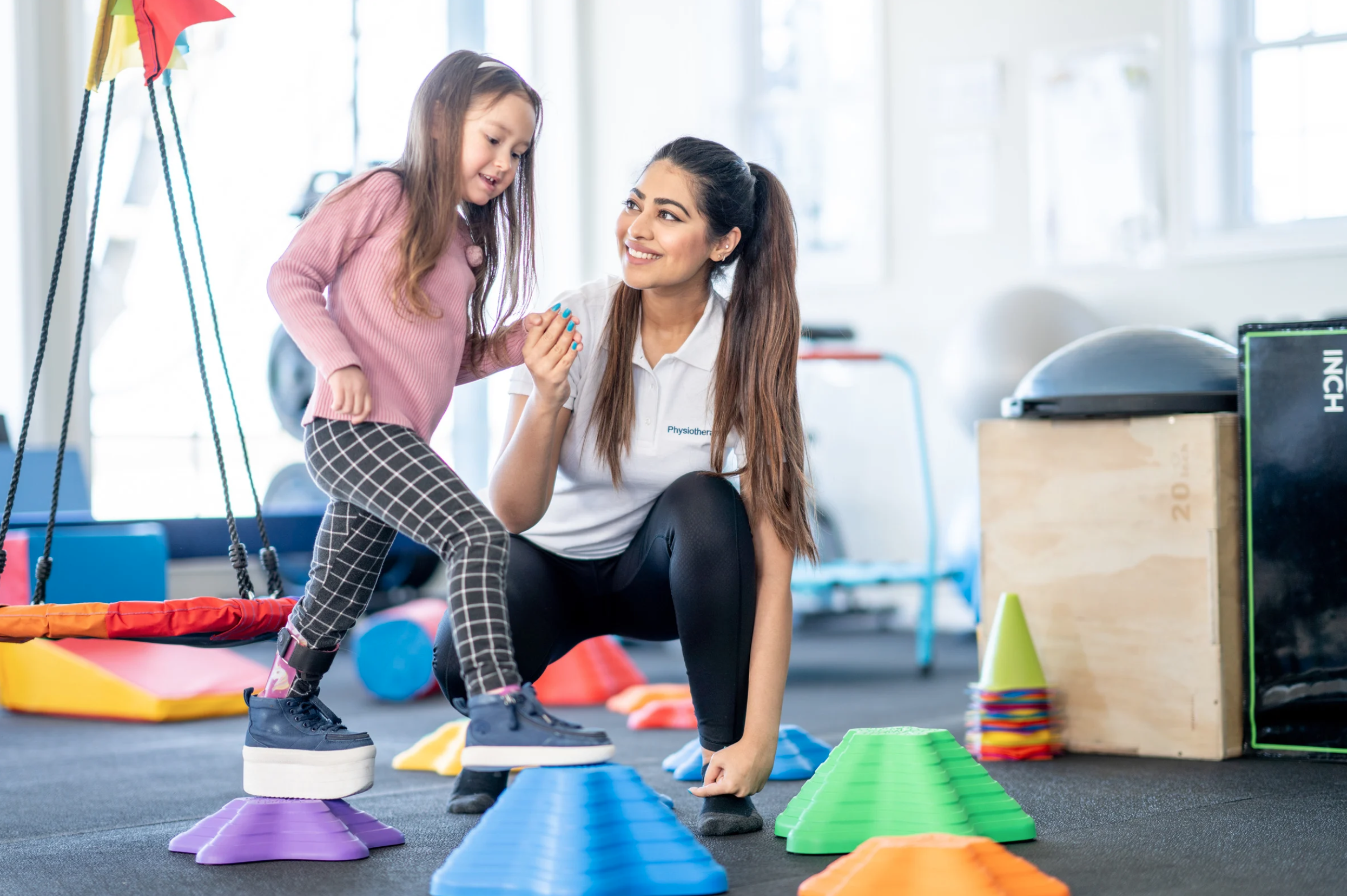 Child doing balance exercises with therapist support
