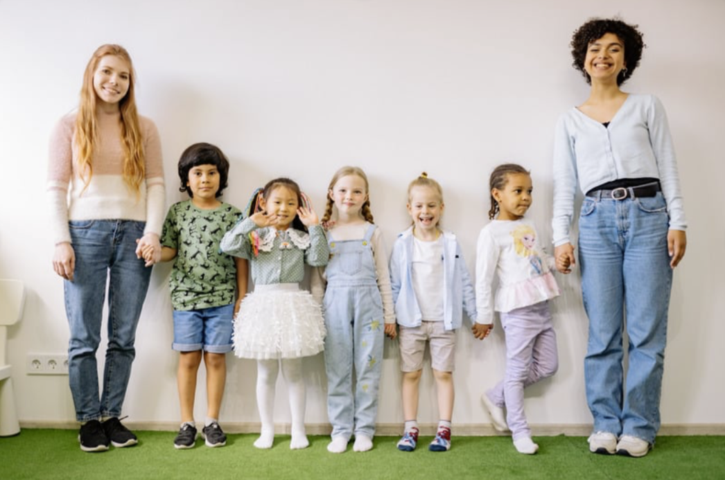 Therapists standing with a group of smiling children